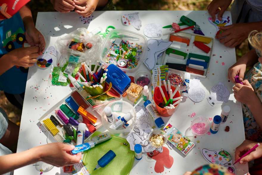 Children at the learning table with art supplies